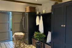 a kitchen with black cabinets and white towels hanging on the rack next to an open door