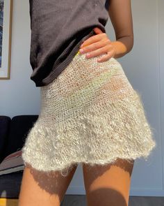 a woman in short shorts with her hands on her hips and the bottom of her skirt showing