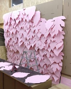 a room with pink paper on the wall and a ladder in front of it that is being worked on