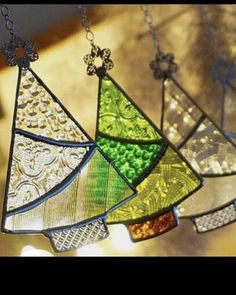 three stained glass christmas trees hanging from chains