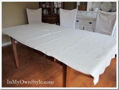 a dining room table with white linens on it