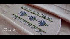 a close up of a piece of cloth on a table with flowers and leaves embroidered onto it