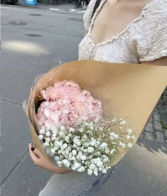 a woman holding a bouquet of flowers on the street