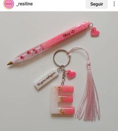 a pink pen and keychain on a white surface