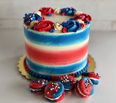 a cake with red, white and blue frosting on it sitting next to some candies