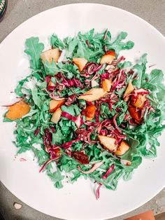 a white plate topped with lettuce and apples