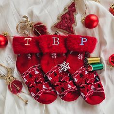 christmas stockings with monogrammed letters and ornaments on a white blanket next to other holiday decorations