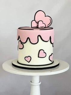 a pink and white cake with hearts on it