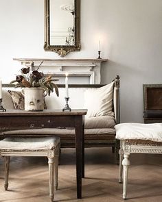 a living room filled with furniture and a mirror on the wall next to a fireplace