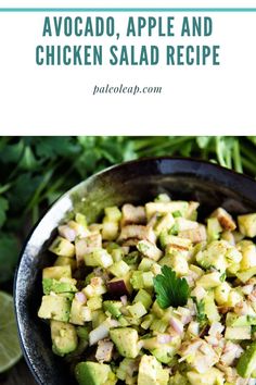 avocado, apple and chicken salad recipe in a black bowl with limes