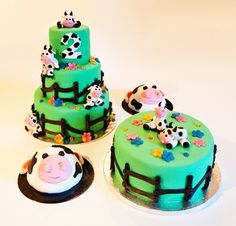 three cakes decorated with farm animals on top of each other in the shape of cows