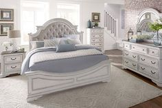 a large white bed sitting in a bedroom on top of a hard wood floor