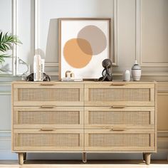 a wooden dresser sitting next to a wall with a painting on it's side