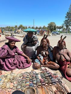 three women sitting on the ground with many bracelets