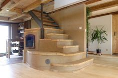 a living room filled with furniture and a fire place under a stair case next to a door