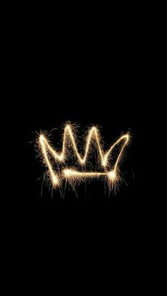 a crown made out of sparklers on a black background with the word king written in it