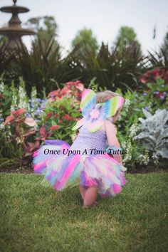 The Rainbow Fairy Tutu This gorgeous tutu is a perfect choice for your little fairy. Made with an assortment of fun colorful colors. Wings and headband can be added through drop down menu. Sizes: Length noted is tutu portion only. Top will be an additional 6-12 inches, depending on size ordered. Newborn - 6 Months Length - 6 inches 6 -12 Months Length - 7 Inches 12M-2T Length - 8 Inches 3/4T Length - 11 Inches 5/6 Length - 12 Inches 7/8 Length - 14 Inches 8/10 Length - 15 Inches 10/12 Length - 1 Toddler Butterfly Costume, Butterfly Halloween Costume, Baby Tutu Dress, Butterfly Halloween, Baby Tutu Dresses, Rainbow Fairy, Fairy Halloween Costumes, Baby Costumes Girl, Butterfly Costume