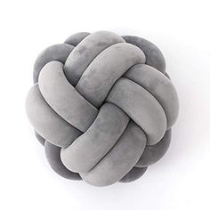 a gray knot pillow sitting on top of a white table