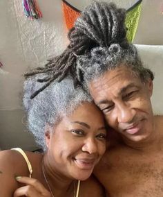 an older man and woman are posing for the camera with their arms around each other