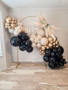 black and gold balloons are arranged in the shape of a arch for a birthday party