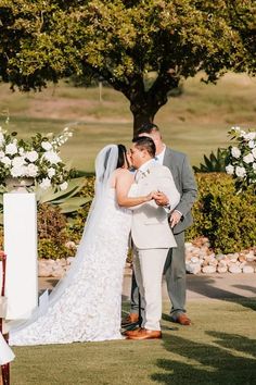 a bride and groom standing in front of the alter at their wedding ceremony with white flowers