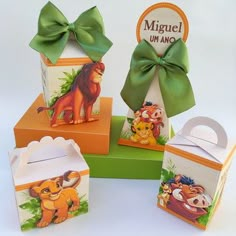 four small boxes with different animal designs on them, one has a green bow and the other has an orange box