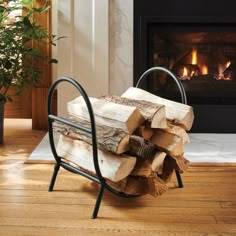 a stack of logs sitting on top of a wooden floor next to a fire place