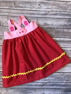 a red dress with pink bunny ears on the front and yellow trim around the waist