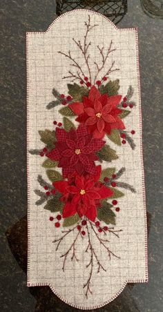 a table runner with poinsettis and leaves on it