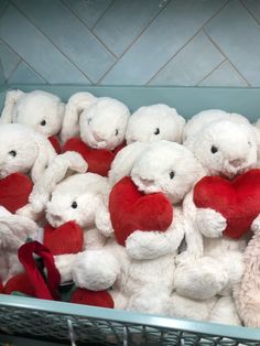 a basket filled with lots of white teddy bears holding red hearts in their mouths and eyes