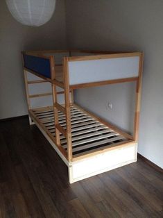 a wooden bunk bed sitting on top of a hard wood floor next to a white wall