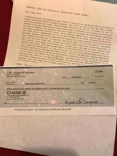 a chequed check from chase q on top of a pile of paper with a pen next to it