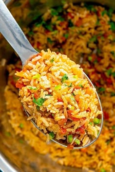 a spoon full of rice and vegetables in a pot