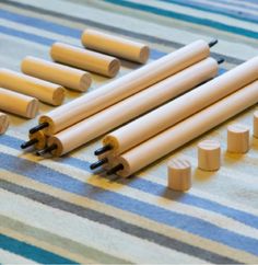 several wooden dowels are lined up on a striped tablecloth with other wood dowels