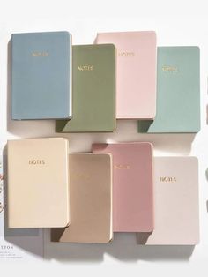 the notebooks are lined up on top of each other in different colors and sizes