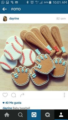 some cookies that are sitting on top of a wooden table with baseball bats and mitts