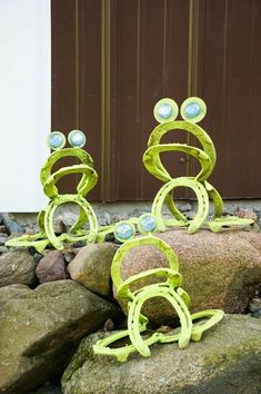 three green sculptures sitting on top of rocks