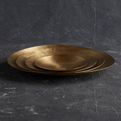 four gold plates stacked on top of each other