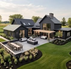 an aerial view of a modern house with outdoor furniture and patio area in the foreground