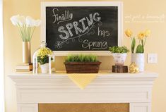 a fireplace mantel decorated with flowers, plants and a chalkboard that says finally spring has sprung