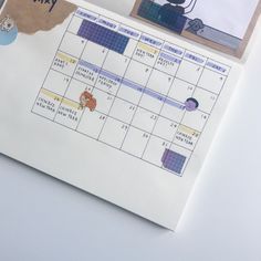 a calendar with stickers on it sitting next to a piece of paper that says happy friday