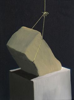 a painting of a rock on top of a block of white paper with a string attached to it