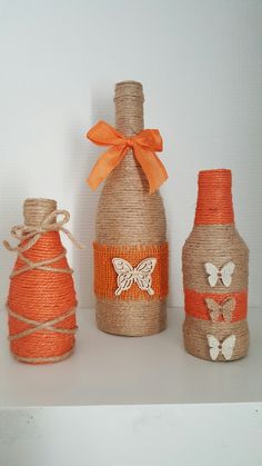 three bottles are decorated with butterflies and twine