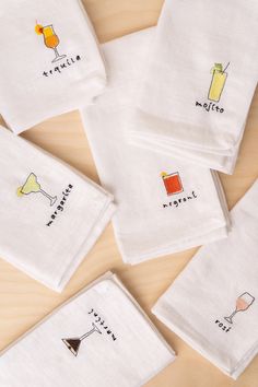 six embroidered cocktail napkins with drinks on them