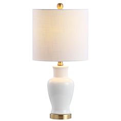 a white table lamp with a gold base and a light shade on the top of it