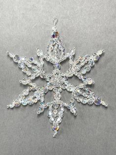 a crystal snowflake ornament on a gray background with lots of small crystals