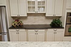 a kitchen with white cabinets and granite counter tops