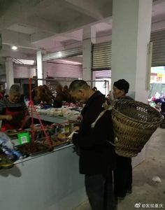 people are standing in line at a food stand with baskets on the counter and one man is holding a basket