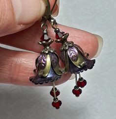 DARK FAIRY FLOWER EARRINGS  ▪️▪️▪️▪️▪️▪️▪️️▪️▪️▪️▪️▪️▪️ These pretty red purple floral earrings are made with super cute Lucite fairy flowers which have been hand painted with an iridescent finish. They have beautiful crystals added in eye catching deep Siam red for perfect sparkle when they move and are finished with antique bronze fish lever back earring hooks and ornate floral bead caps. They are very light weight and are perfect for special occasions, festivals and bridesmaids yet cute enoug Whimsigoth Earrings, Fae Jewelry, Dark Red Jewelry, Whimsigoth Jewelry, Bronze Jewellery, Dangly Earring, Antique Bronze Jewelry, Fairy Flowers, Pink Gift Box