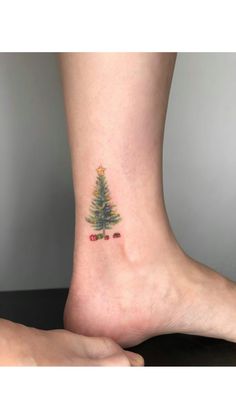 a small christmas tree tattoo on the ankle